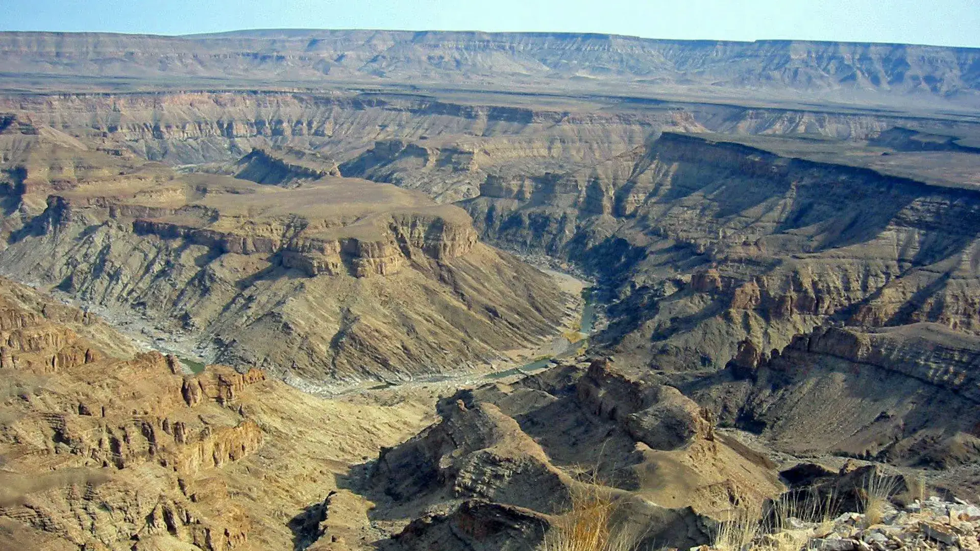 Fish River Canyon winding through layered rock walls in evening light